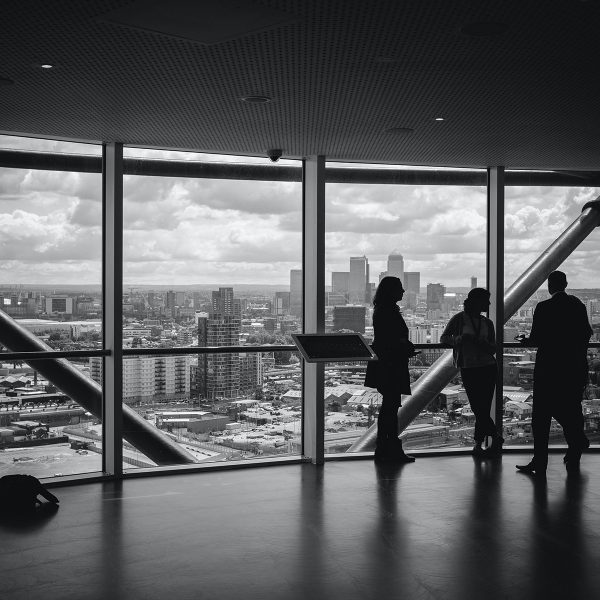 business people talking next to office window high up